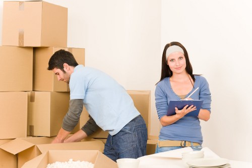 Professional movers carrying furniture during a Dalston home relocation